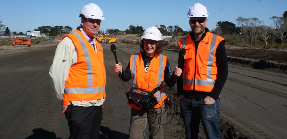 Graham Blick (left), Chief Geodesist at LINZ, and survey manager Will Newall (right), with Alison Ballance at the construction site of the MacKays to Peka Peka expressway.