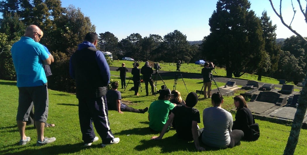 Friends of Blessie Gotingco gather at the cemetery. A blue police tent is in the background.
