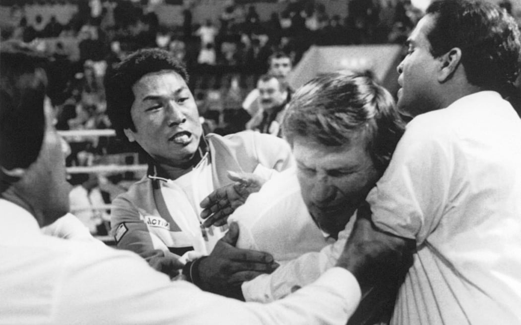 South Korean assistant boxing coach Lee Chung-Ha grabs referee Keith Walker from New Zealand after South Korean bantamweight Byun Jong-Il was beaten on a points decision (1-4) by Bulgarian Alexander Hristov in their Olympîc bout, 22 September 1988 in Seoul.
