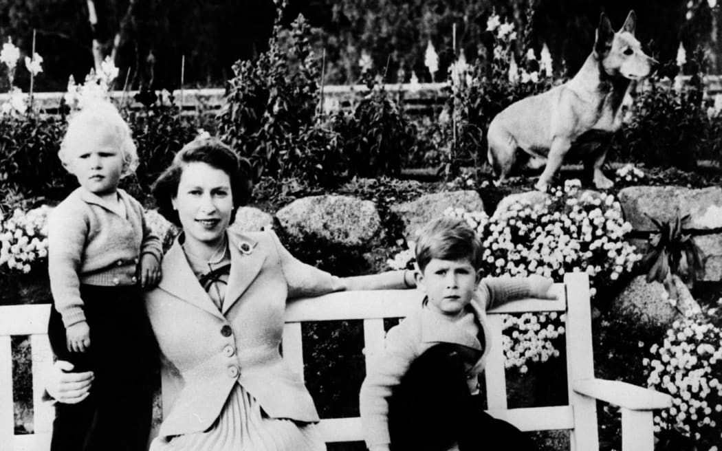 Undated picture of the Queen Elizabeth II, her two children Charles (R) and Ann and a corgi posing in Balmoral. (Photo by - / AFP)