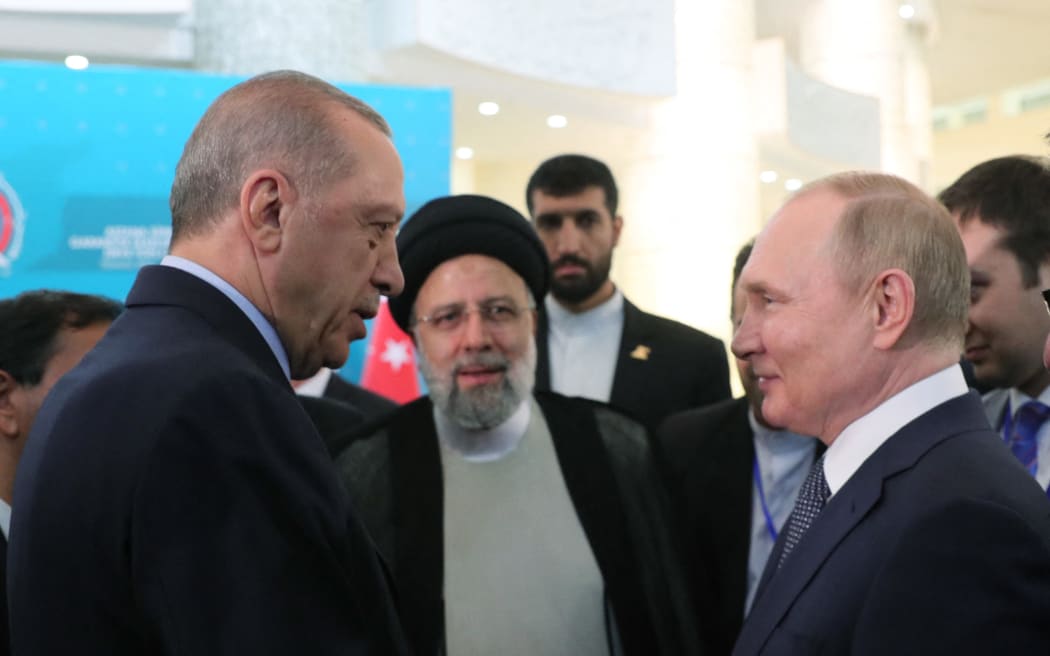 Turkish President Recep Tayyip Erdogan (left) speaking with Russian President Vladimir Putin  and Iranian President Ebrahim Raisi, as they arrive for a joint news conference at the end of the Astana Trilateral Summit at the Tehran International Conference Hall in Tehran.