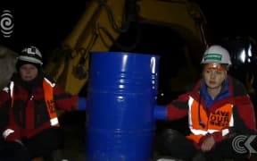 Greenpeace activists chain themselves to digger