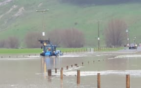 A tractor towing a vehicle through a flooded field near the township of Te Karaka on 22 June 2023.