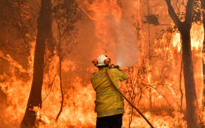 A firefighter conducts back-burning measures to secure residential areas from encroaching bushfires in the Central Coast, some 90-110 kilometres north of Sydney on December 10, 2019.