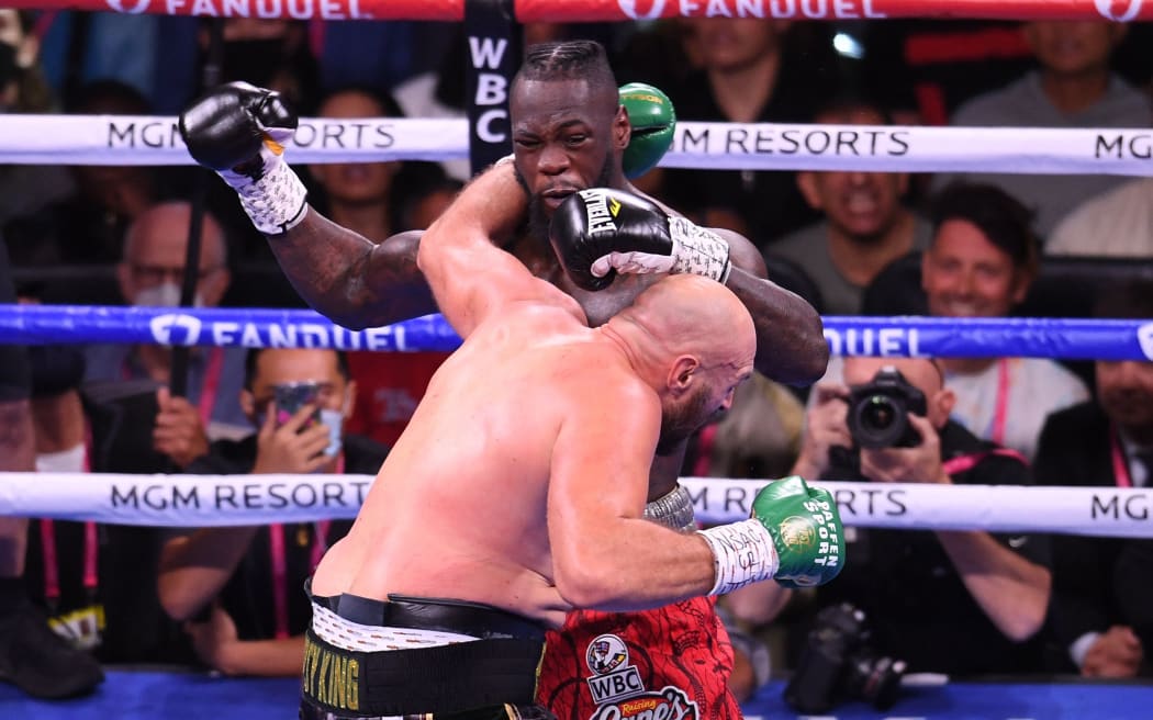 WBC heavyweight champion Tyson Fury of Great Britain (L) and US challenger Deontay Wilder (R) exchange punches during a fight for the WBC/Lineal Heavyweight title at the T-Mobile Arena in Las Vegas, Nevada, October 9, 2021. (Photo by Robyn Beck / AFP)