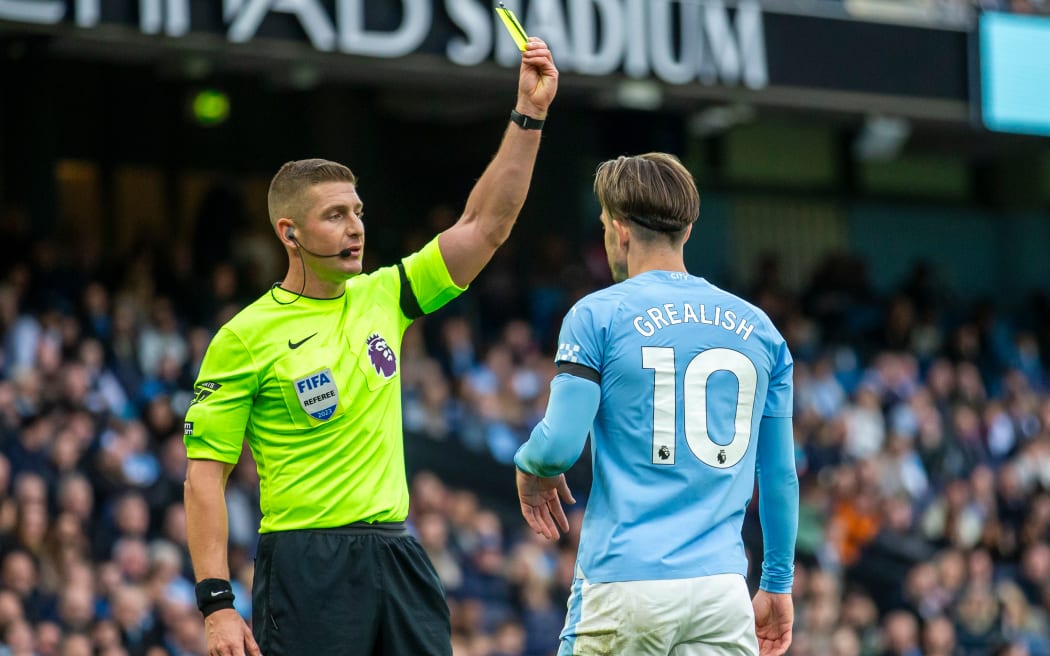 Jack Grealish of Manchester City receives a yellow card from the referee