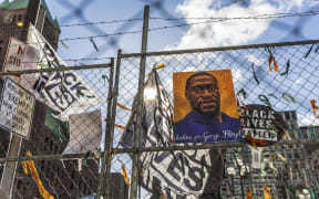 A poster with George Floyd's picture and a sign reads that "I Can't Breathe" hang from a security fence outside the Hennepin County Government Center in Minneapolis, Minnesota.