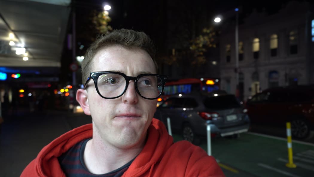 Josh Davies waits for a taxi in the city.