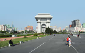 Pyongyang, North Korea - May 1, 2019: People play tennis next to Arch of Triumph. A monument built in Pyongyang in honor of the Korean resistance of 1925-1945 against the Japanese occupiers