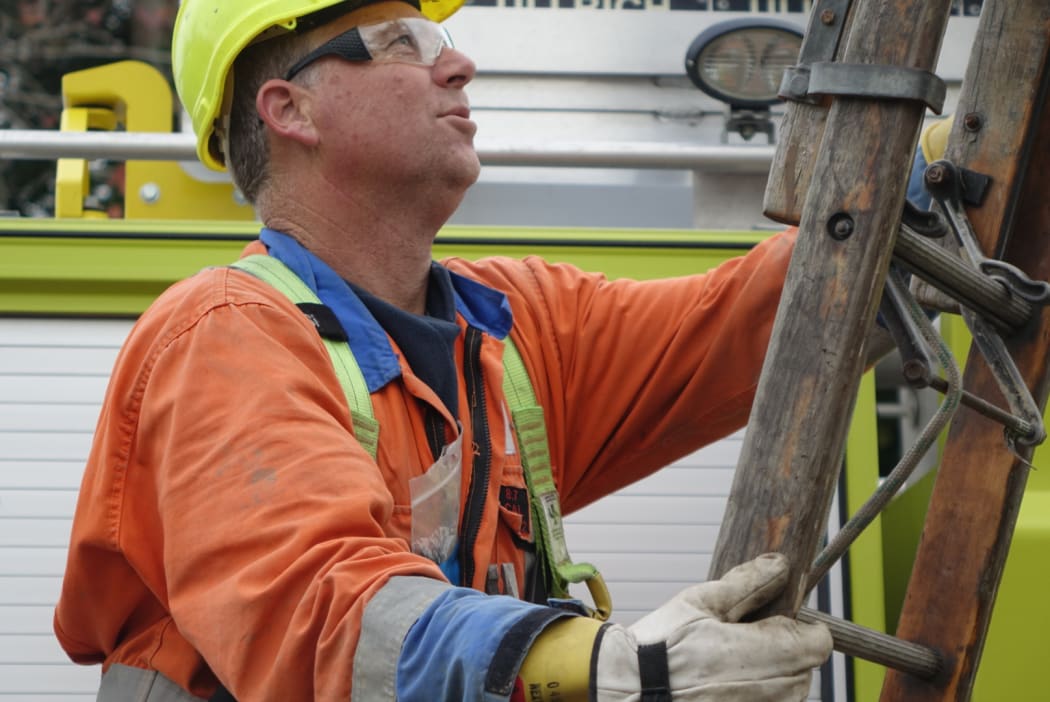 Linesman Andrew Henare works to check homes on Anzac Parade in Whanganui.