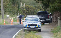 A police Serious Crash Unit investigator surveys the scene on Ngapipito Road, south of Kaikohe.