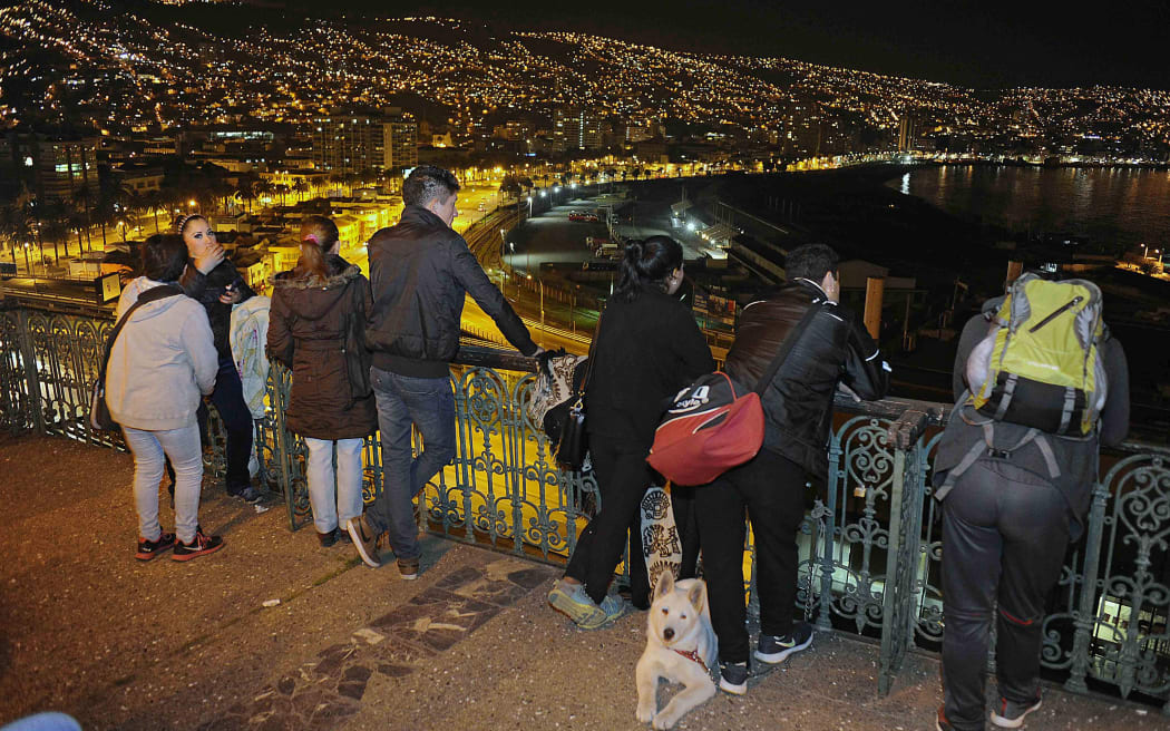 People in the city of Valparaiso keep a close eye on the shoreline after a massive quake hit off the Chilean coast.