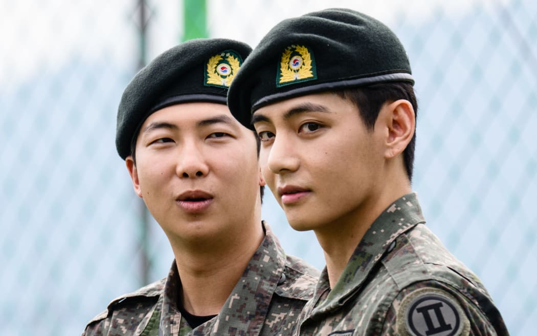 K-pop boy band BTS member V (R) looks on as RM reacts, after their release from 18 months of South Korean military service.