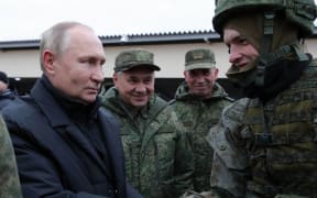 Russian President Vladimir Putin (L) and Defence Minister Sergei Shoigu (C) meet soldiers during a visit at a military training centre of the Western Military District for mobilised reservists, outside the town of Ryazan on October 20, 2022. (Photo by Mikhail Klimentyev / Sputnik / AFP)