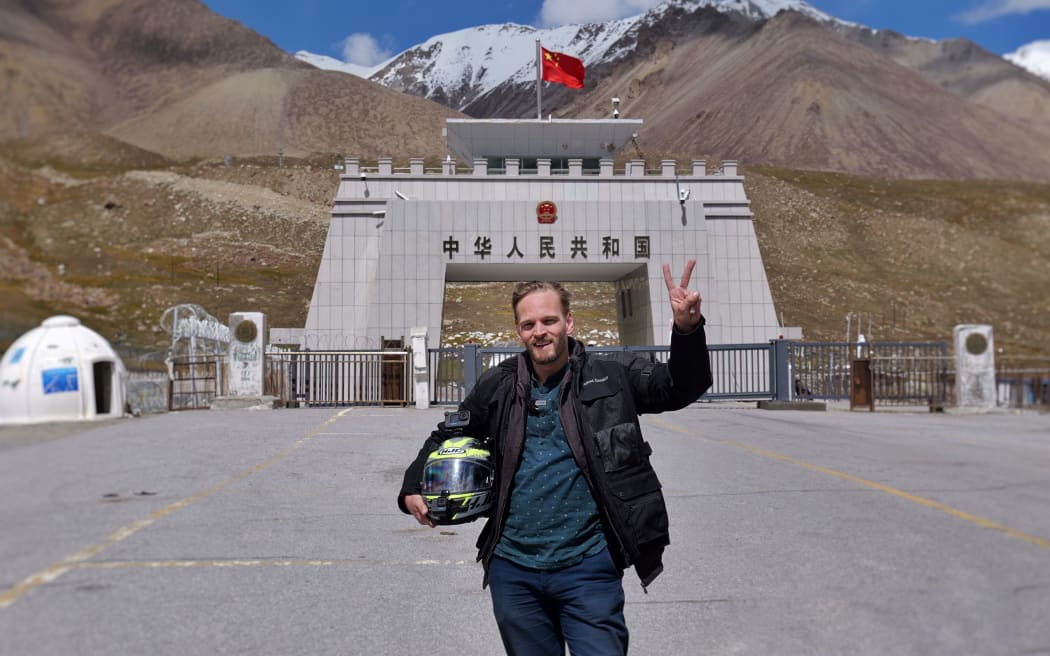 Karl Rice poses for a photograph at Khunjerab Pass, the highest international border crossing in the world.