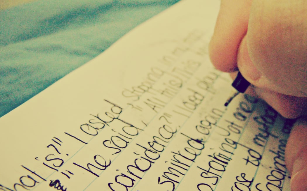 Child hand writing in exercise book
