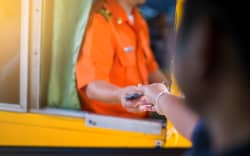 Driver pay for the expressway. Man pays money to a cashier for a toll road toll gate motorway entrance.