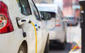 Power supply for electric car charging.  Electric car charging station. Close up of the power supply plugged into an electric car being charged.