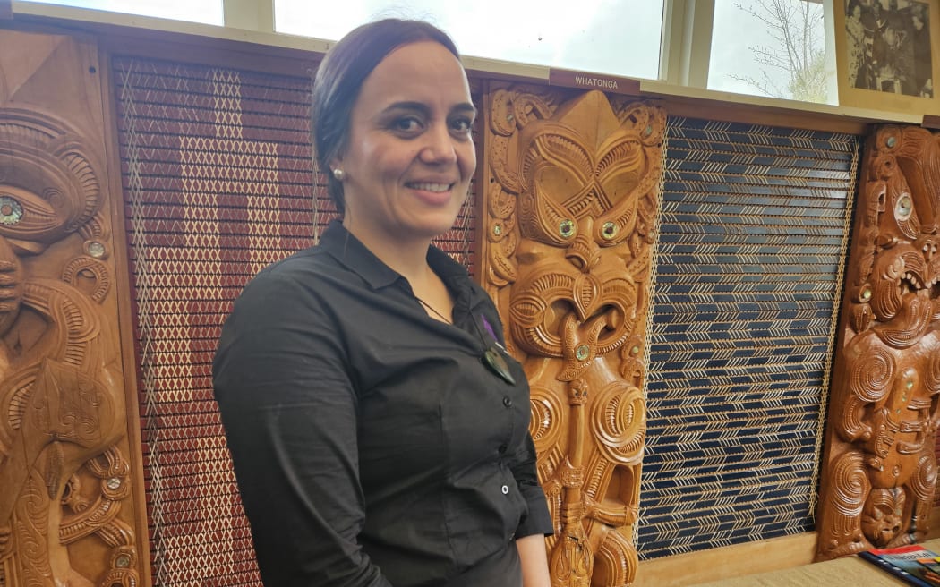 Whātonga: In Search of Man Project lead Shannon Story with a carving of Whātonga behind her.