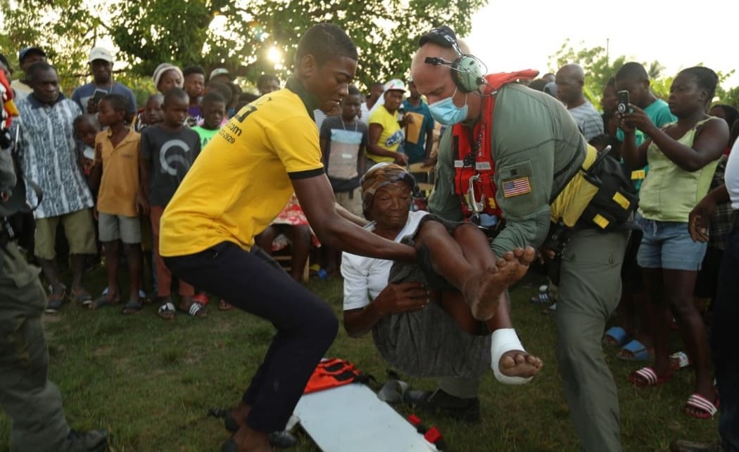 This handout image courtesy of the US Coast Guard shows Petty Officer 3nd Class Nick Trimple conducts a evacuation in the Cavaillon area, Haiti, on August 21, 2021.