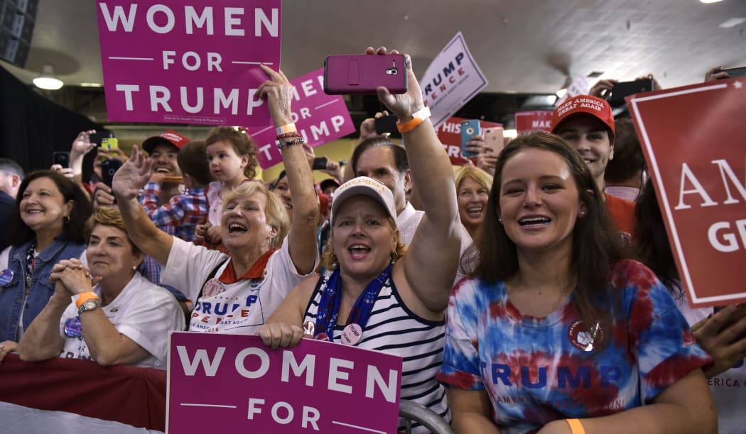 Supporters cheer as US Republican presidential nominee Donald Trump speaks during a rally in the Special Events Center of the Florida State Fairgrounds in Tampa, Florida on November 5, 2016.