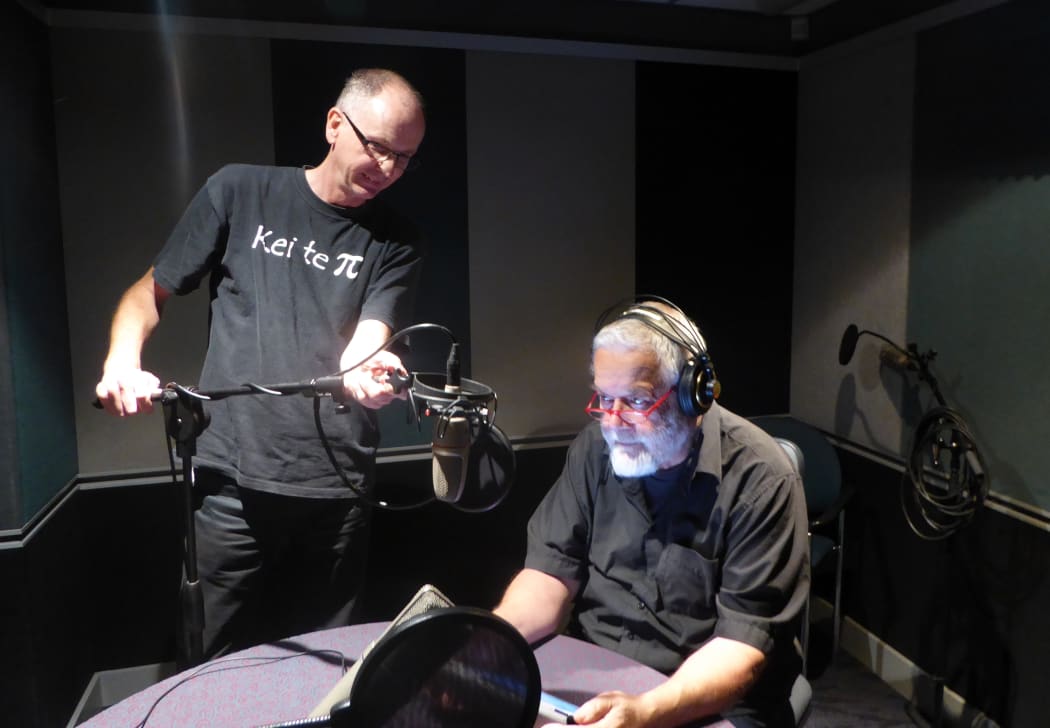 William gets ready to record while his producer makes a fine adjustment to his microphone placement.