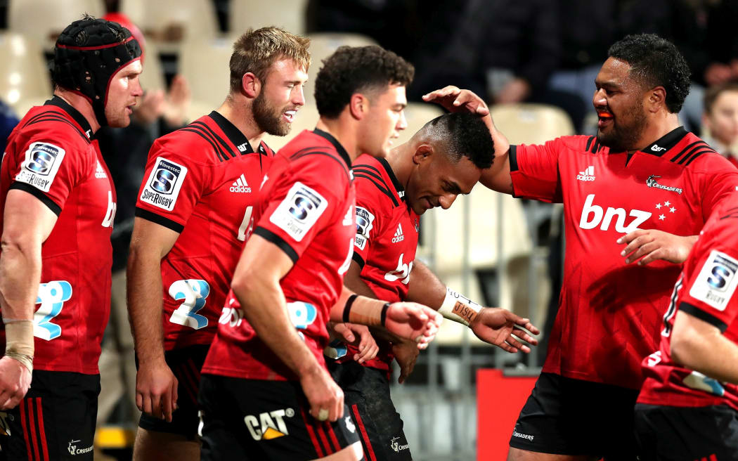 The Crusaders celebrate one of Sevu Reece's two tries in the win over the Hurricanes.