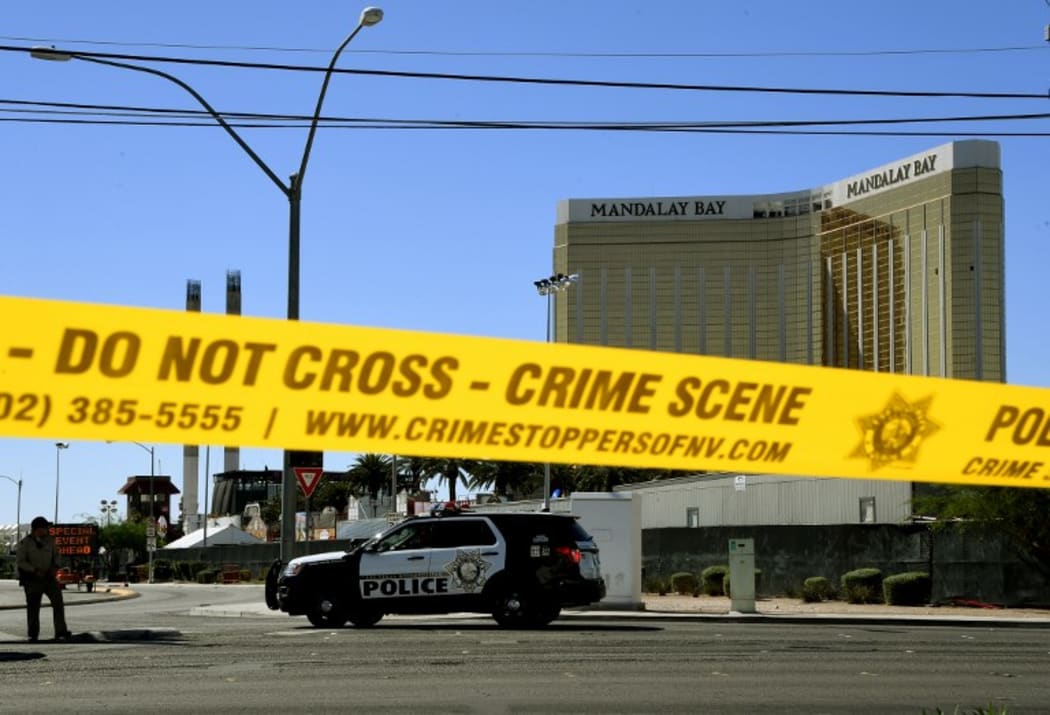 Crime scene tape surrounds the Mandalay Hotel with shooter's window damage in top right.