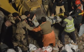 A person is carried from the debris after a factory collapsed in Lahore
