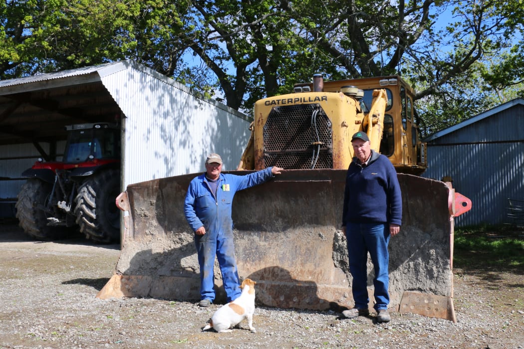 Anthony Harper and John Stewart in front of a Cat D9G