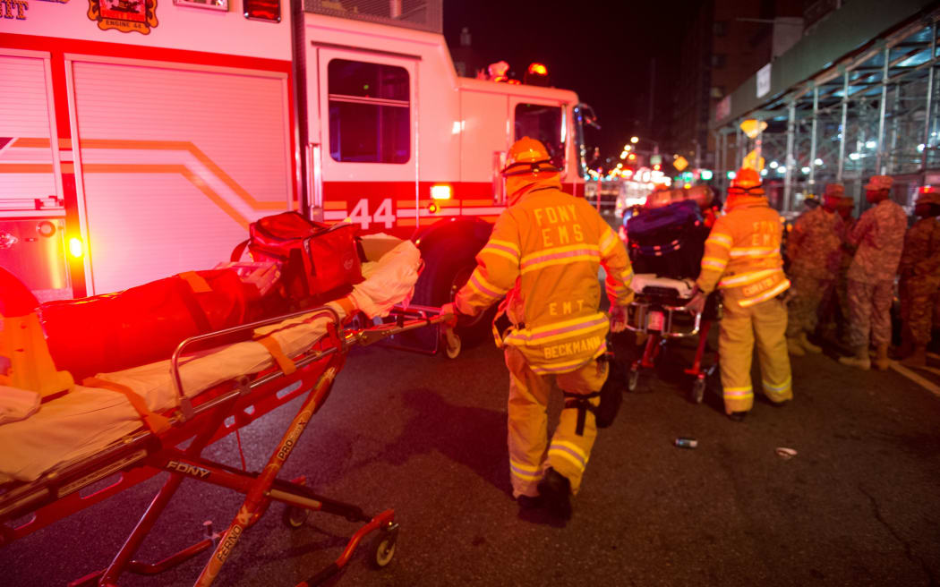 Firefighters help clear the scene of the explosion on West 23rd Street in New York