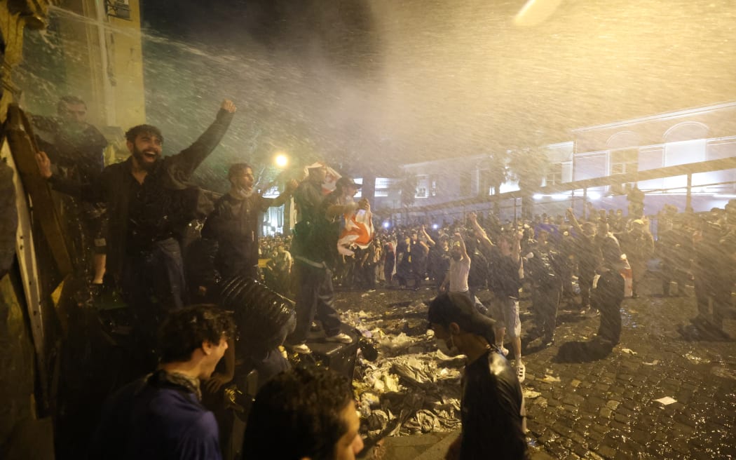 Demonstrators set up a barricade to block the side entrance of Georgian Parliament during a rally against a controversial "foreign influence" bill, after parliament advanced the measure that Brussels has warned would harm Tbilisi's long-standing European aspirations in Tbilisi on May 1, 2024. (Photo by Giorgi ARJEVANIDZE / AFP)