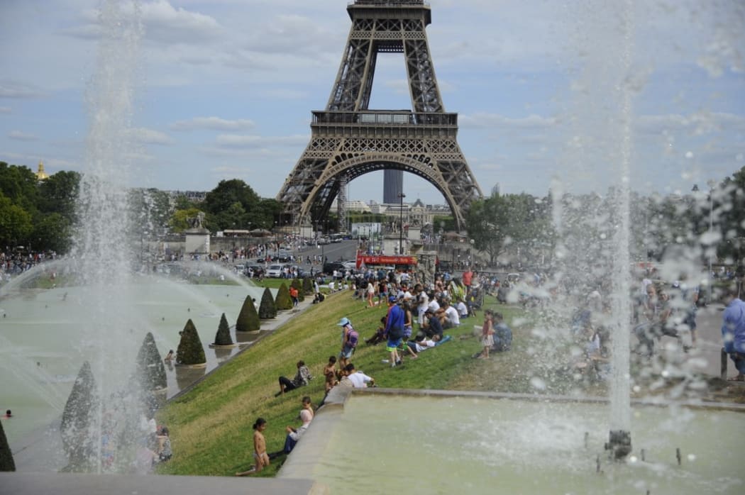 People in front the Eiffel Tower in Paris as temperatures degrees reach 41 Celsius.