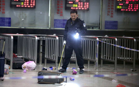 A Chinese police investigator inspects the scene of the attack.