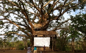 The cinema screen (2 sheets we'd brought attached to a giant banyan tree that somehow survived Cyclone Pam) constructed by the 'can do mob' of Yakel village, just weeks after the cyclone. Incredibly they insisted we come back to show the film as planned.  - Contact Films