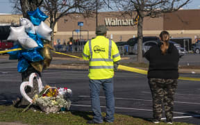Onlookers watch as law enforcement investigates the site of a fatal shooting in a Walmart on November 23, 2022 in Chesapeake, Virginia. Following the Tuesday night shooting, six people were killed, including the suspected gunman.