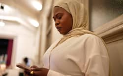 Nidal Saeed checks her phone for updates from her cousin in Sudan. (ABC News: West Matteeussen)