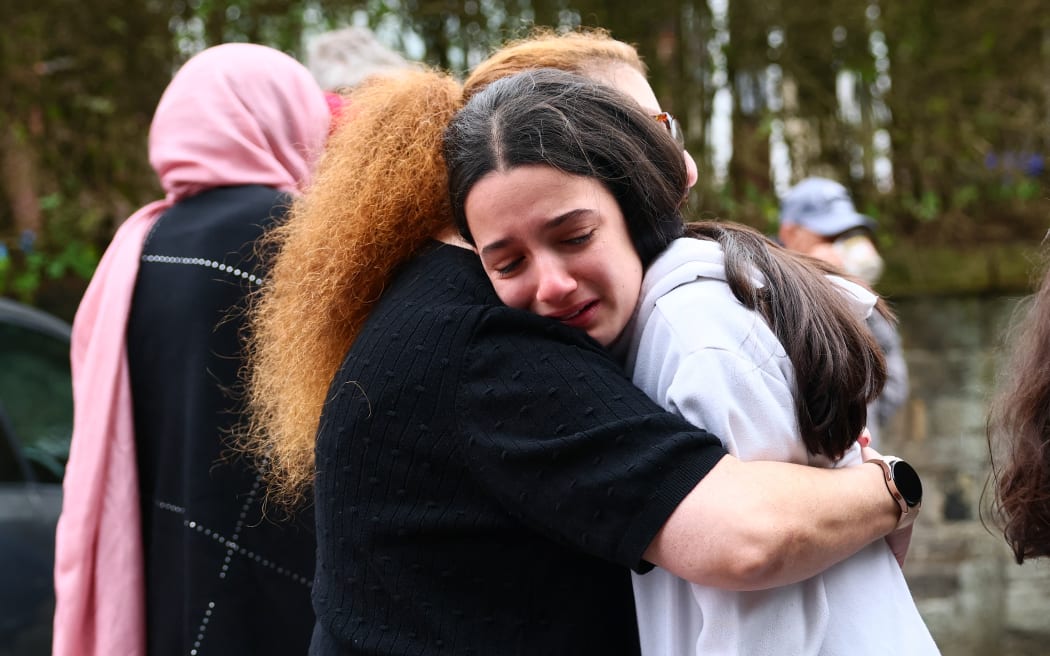 Members of the community comfort each other near Heaton Park Hebrew Congregation Synagogue in Crumpsall, north Manchester, on October 2, 2025, following a "major incident" at the synagogue. Four people were injured and a suspected knifeman shot by police Thursday after a car ramming and stabbing incident outside a synagogue in Manchester, officials said. Greater Manchester Police declared a "major incident" shortly after 9:30am (0830 GMT) after officers were called to the Heaton Park Hebrew Congregation Synagogue in the Crumpsall neighbourhood of the northwestern city. (Photo by Paul Currie / AFP)