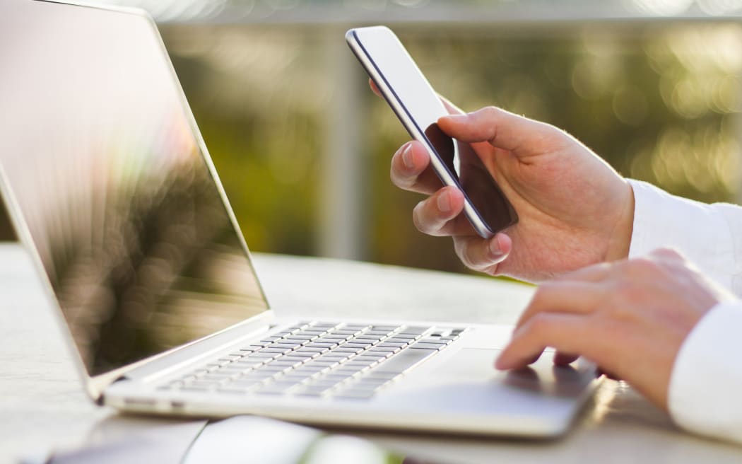 businessman with cellphone and laptop at morning