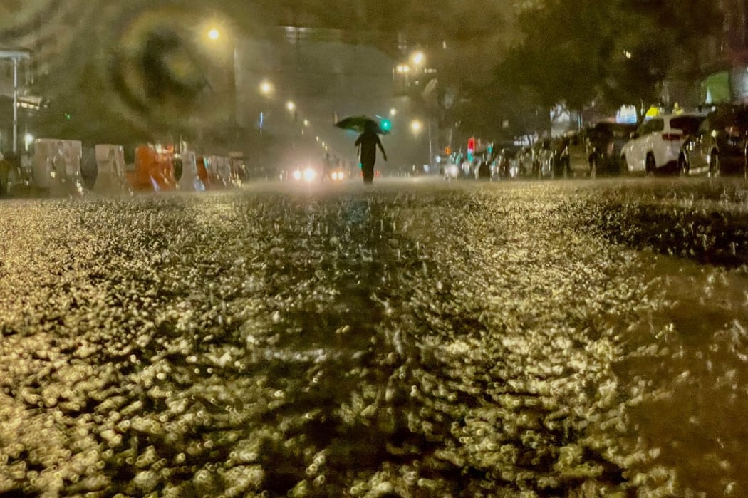 A person makes their way in rainfall from the remnants of Hurricane Ida on September 1, 2021, in the Bronx borough of New York City.