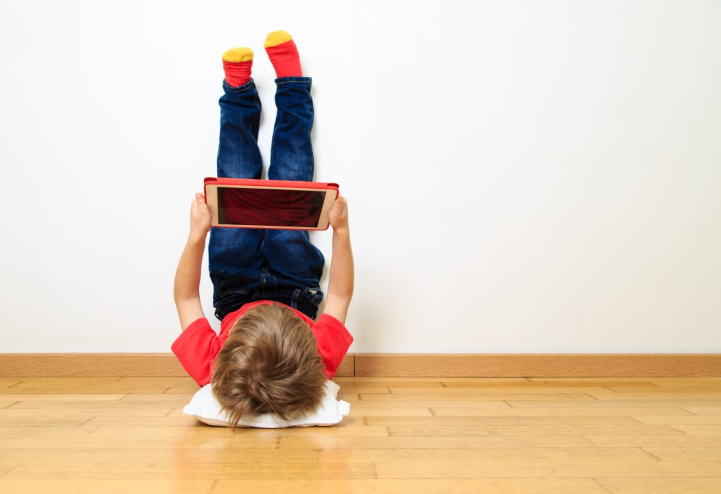 little boy looking at touch pad at home