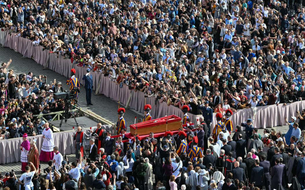 Pallbearers, next to Swiss Guards, carry the coffin of the late Pope Francis as it is transported from the chapel of Santa Marta to St Peter's Basilica, following the Pope's death, in the Vatican on April 23, 2025. The Pope died of a stroke, the Vatican announced hours after the death on April 21, 2025, of the 88-year-old reformer who inspired devotion but riled traditionalists during 12 years leading the Catholic Church. (Photo by Alberto PIZZOLI / AFP)