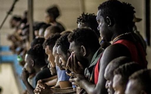 Spectators watch an amateur boxing match at the multi-purpose hall in Honiara Solomon Islands.