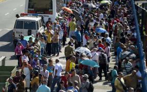 People queue outside Venezuela's Central Bank (BCV) in Caracas in an attempt to change 100-bolivar notes before they become worthless.