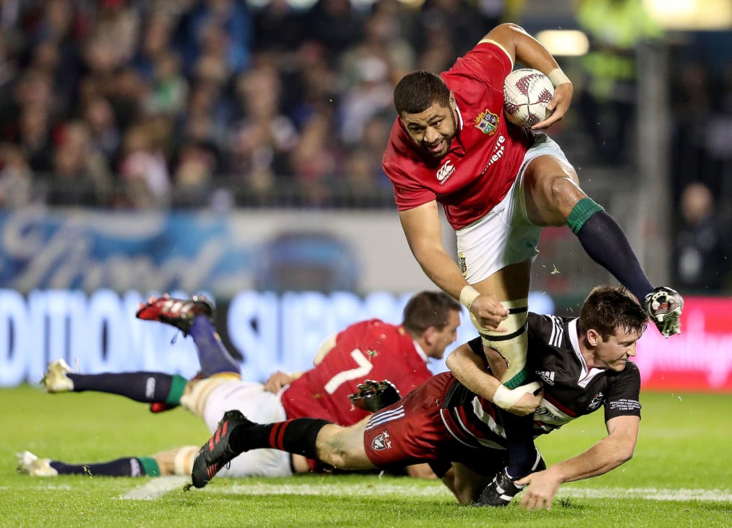 Jack Stratton of Barbarians makes a tackle on the Lions' Taulupe Faletau.