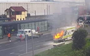 An ambulance on fire outside Ōtāhūhū Station.