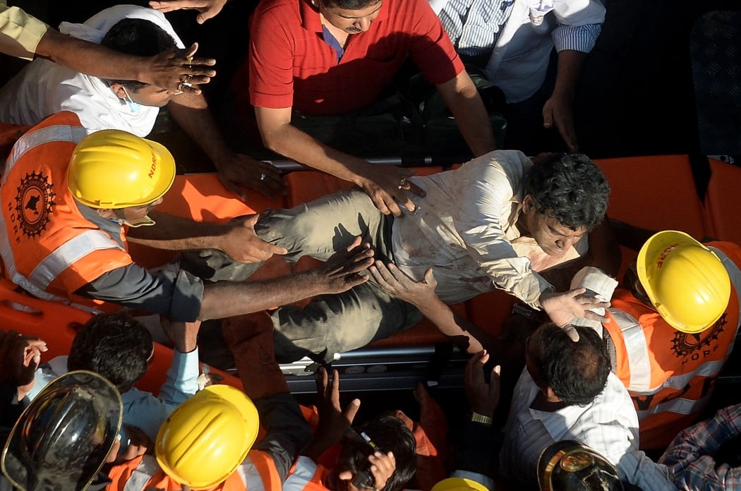 Rescuers pull a man from the rubble of the collapsed building.