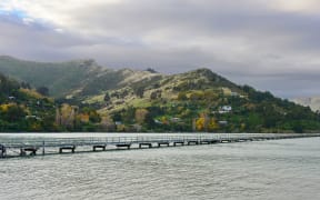 Governors Bay jetty and Port Hills in the background in Christchurch, New Zealand