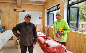 Tipene Kawana (left) standing in the carving studio with the carvings for the new wharenui.