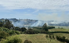 A large vegetation fire continues to burn along the railway line by Wainui South Road, Whakamarama.
